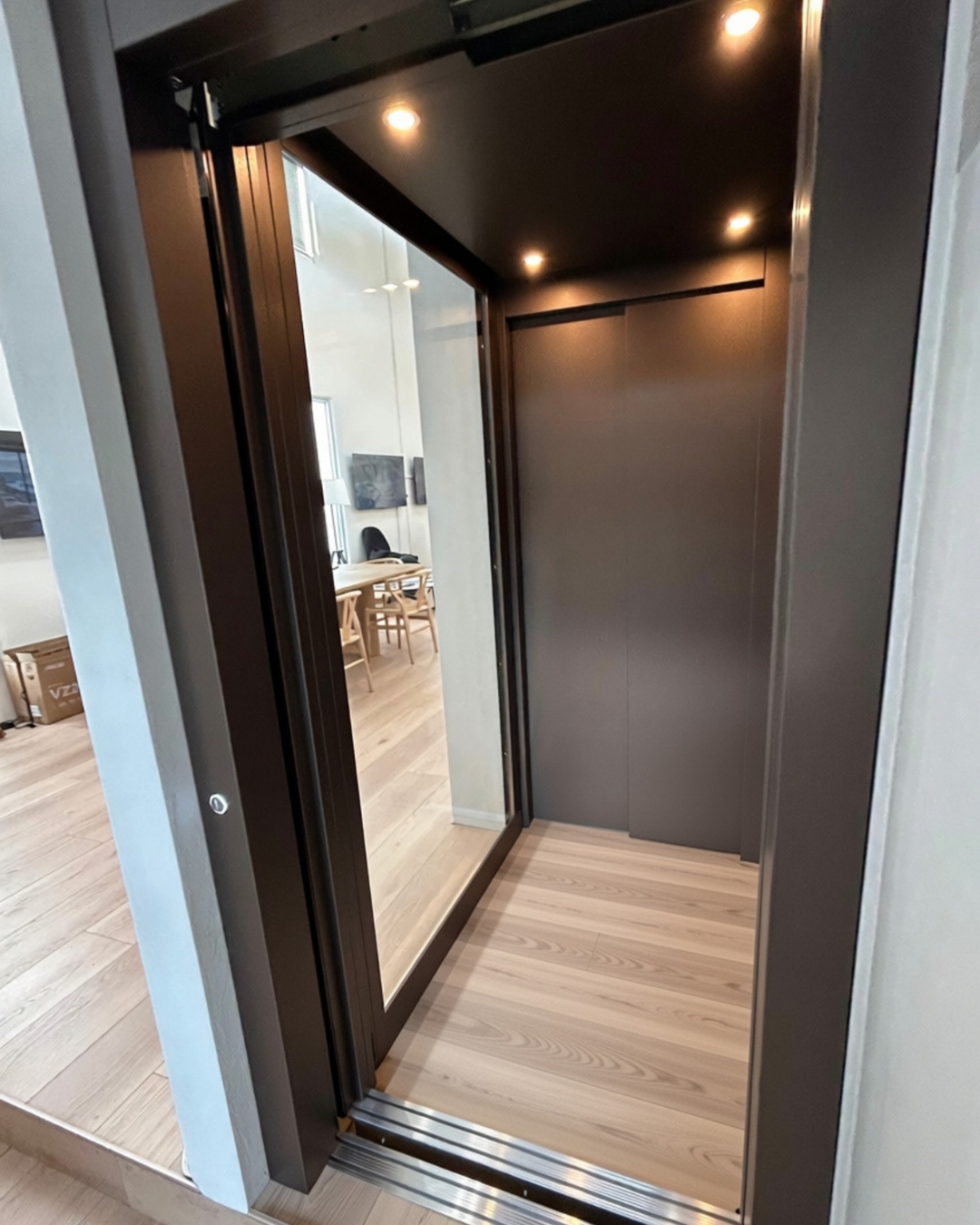 Brushed bronze cabin walls with warm spotlights and custom timber flooring