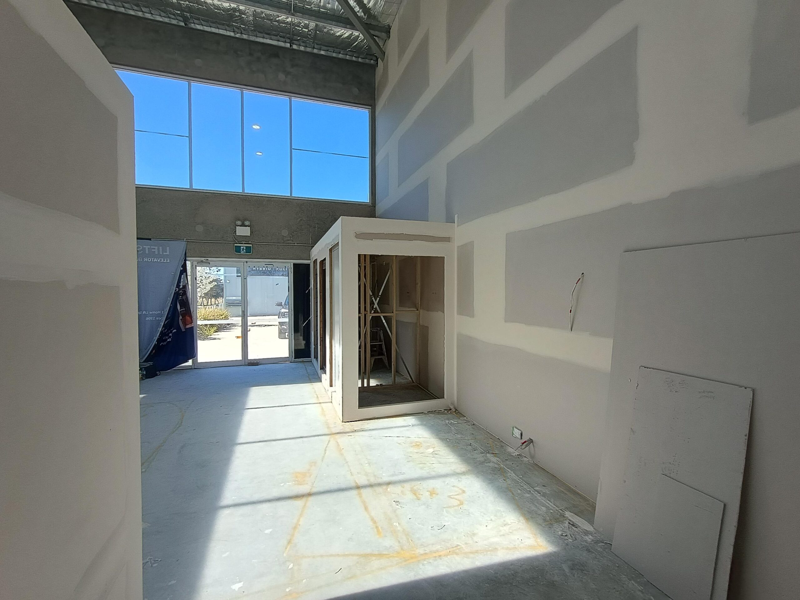 Entrance of the new Lift Shop Canberra showroom being built in Fyshwick, with a Lift Shop banner and a framed home lift enclosure