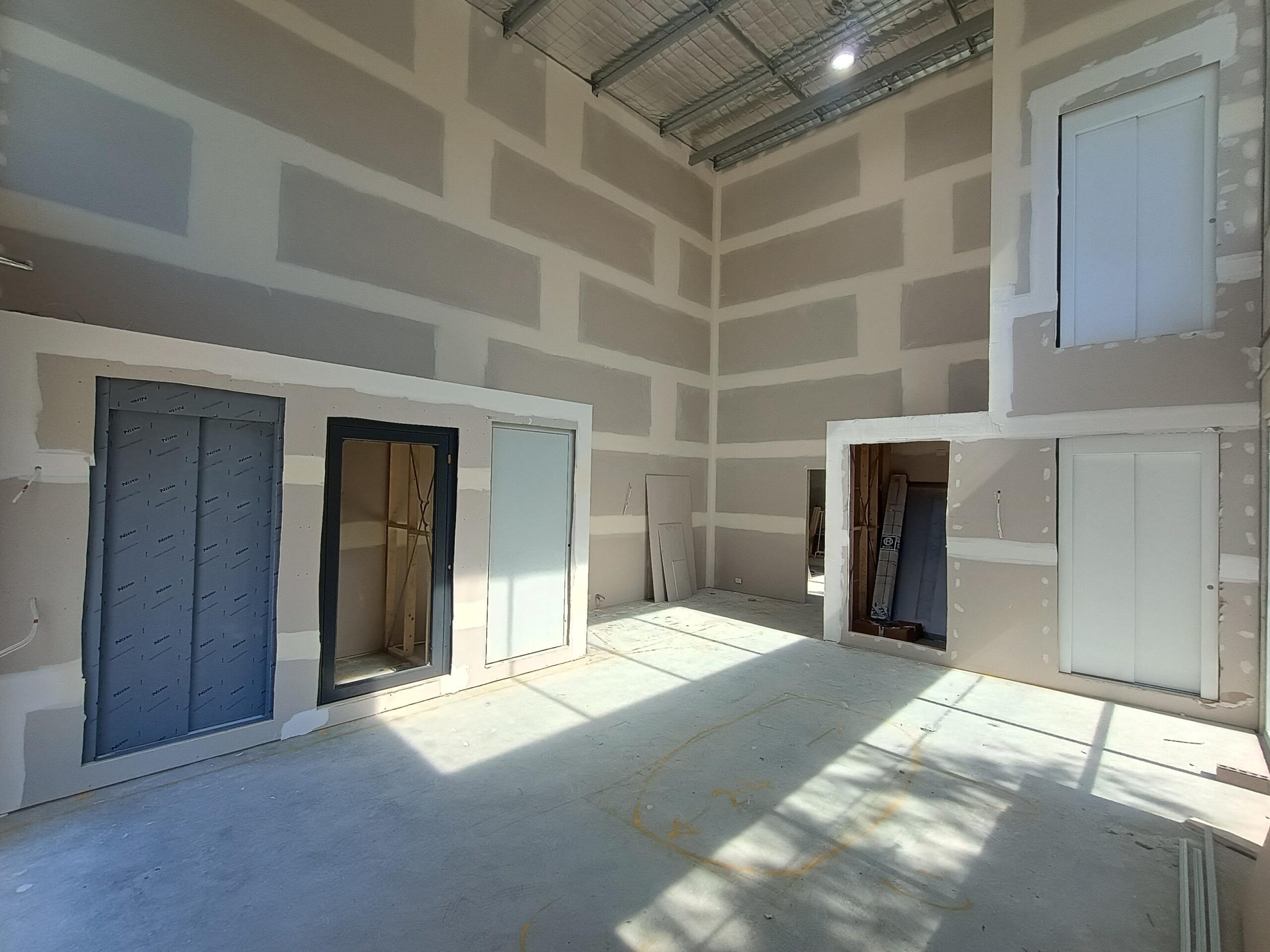 Swing and sliding home lift landing doors being fitted into new walls at the Lift Shop Canberra showroom in Fyshwick