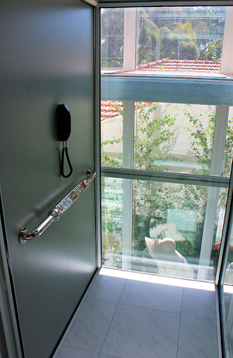 Surface-mounted plastic emergency phone in a standard home lift cabin