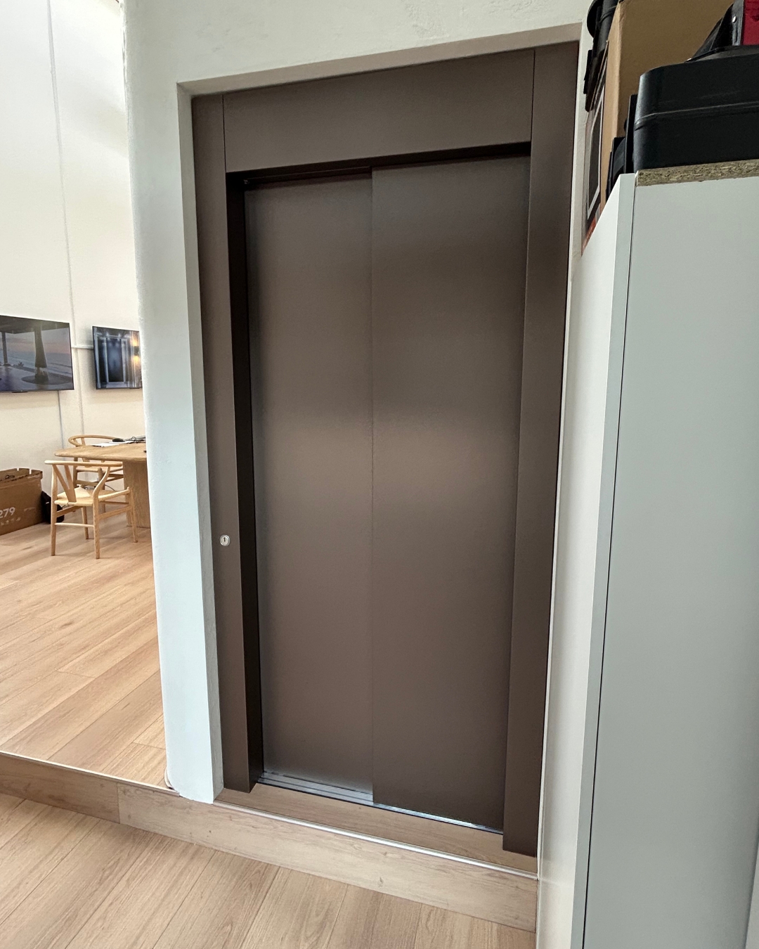 Brushed bronze sliding landing doors on a C Series home lift