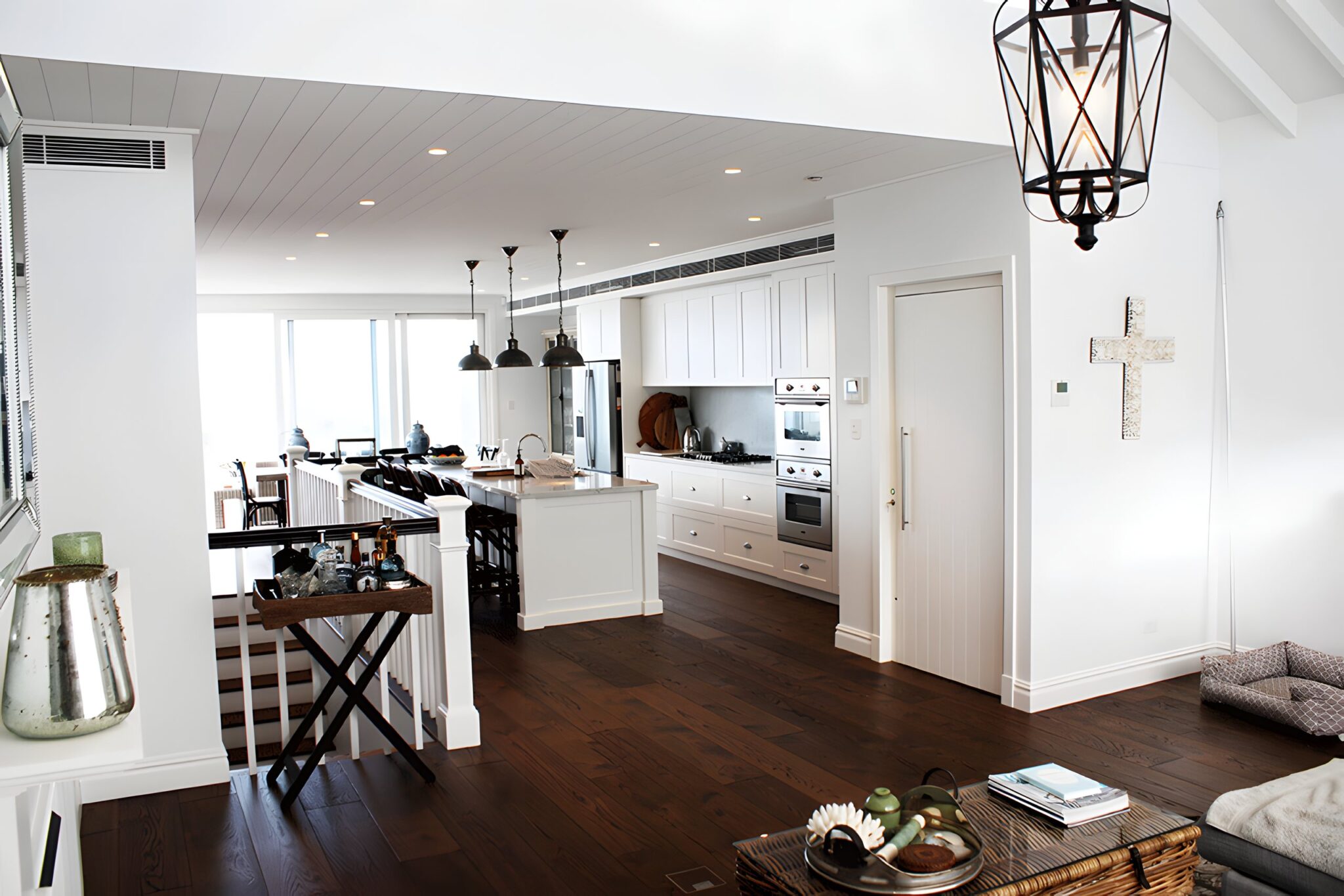 Open-plan kitchen and living area with timber floors and a pendant lantern in a home in Sydney's Eastern Suburbs