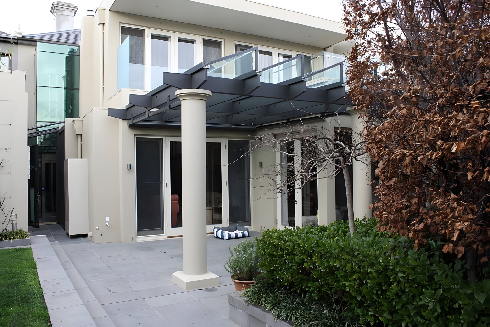 Rear of the stately Albert Park terrace with a pergola, garden and the glass lift shaft at the side
