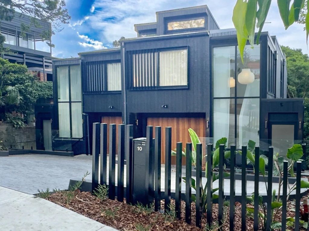 Dark timber-clad modern home with slatted front fence in Balgowlah