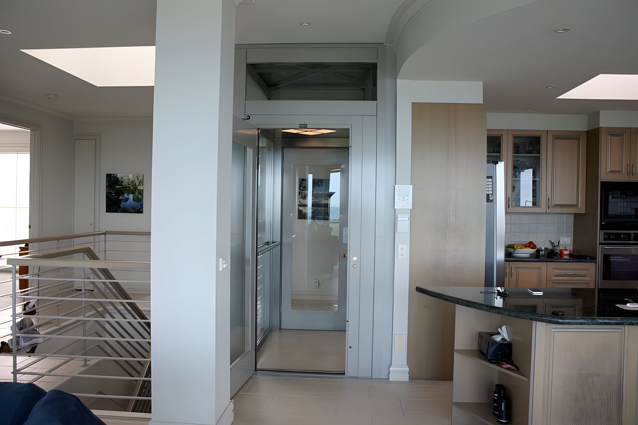Finished custom ElfoLift with glass doors beside the kitchen and stairwell of a Black Rock beachfront home in Melbourne