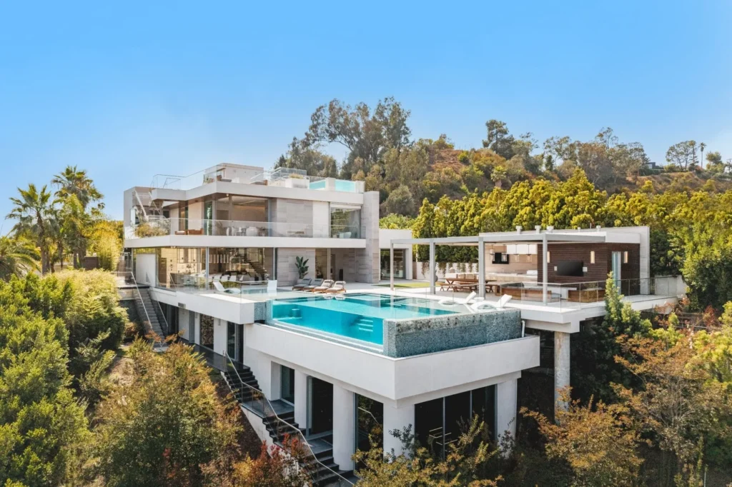 Aerial view of the Beverly Hills hillside home with glass-edged infinity pool and hillside terraces