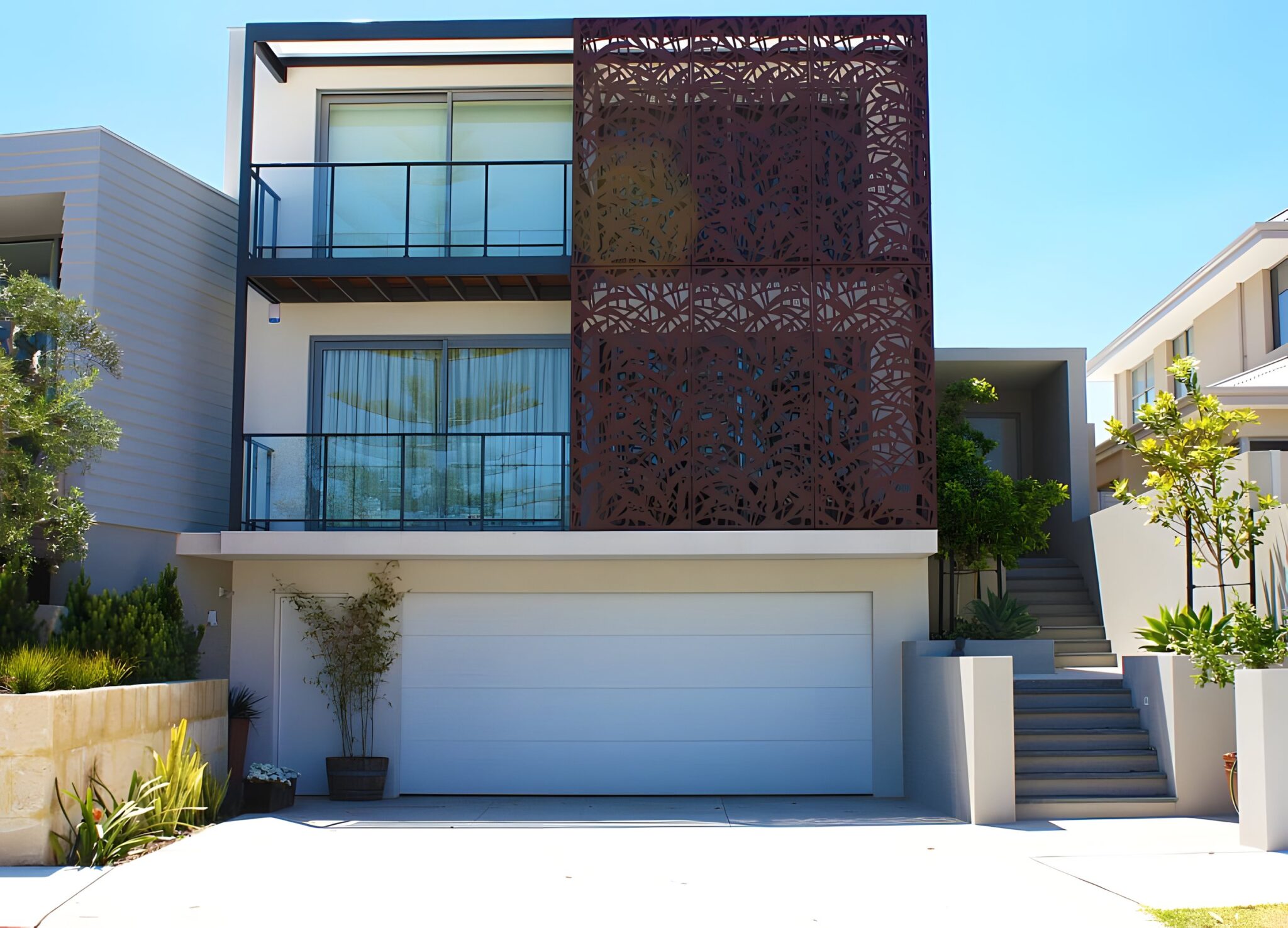 Three storey City Beach home in Perth with glass balconies, a perforated rust coloured screen and a white garage door