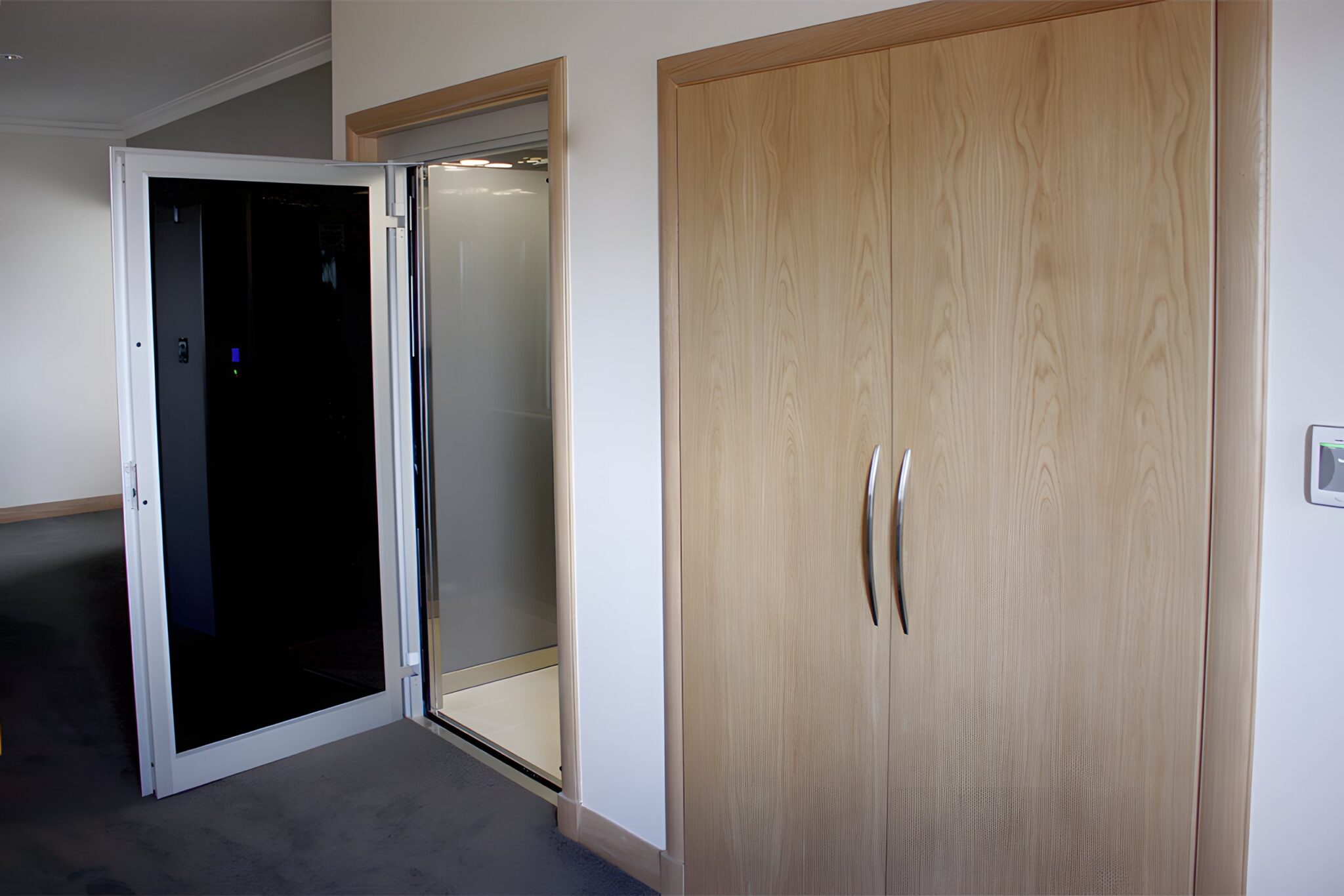 Open E1 swing door lift with black glass beside tall Tasmanian Oak veneer double doors in a Dianella home