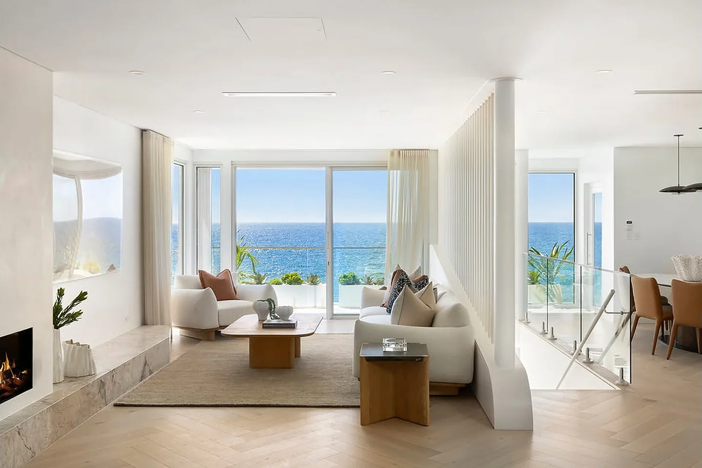 Living room in a Freshwater home looking across a glass balustrade to the ocean