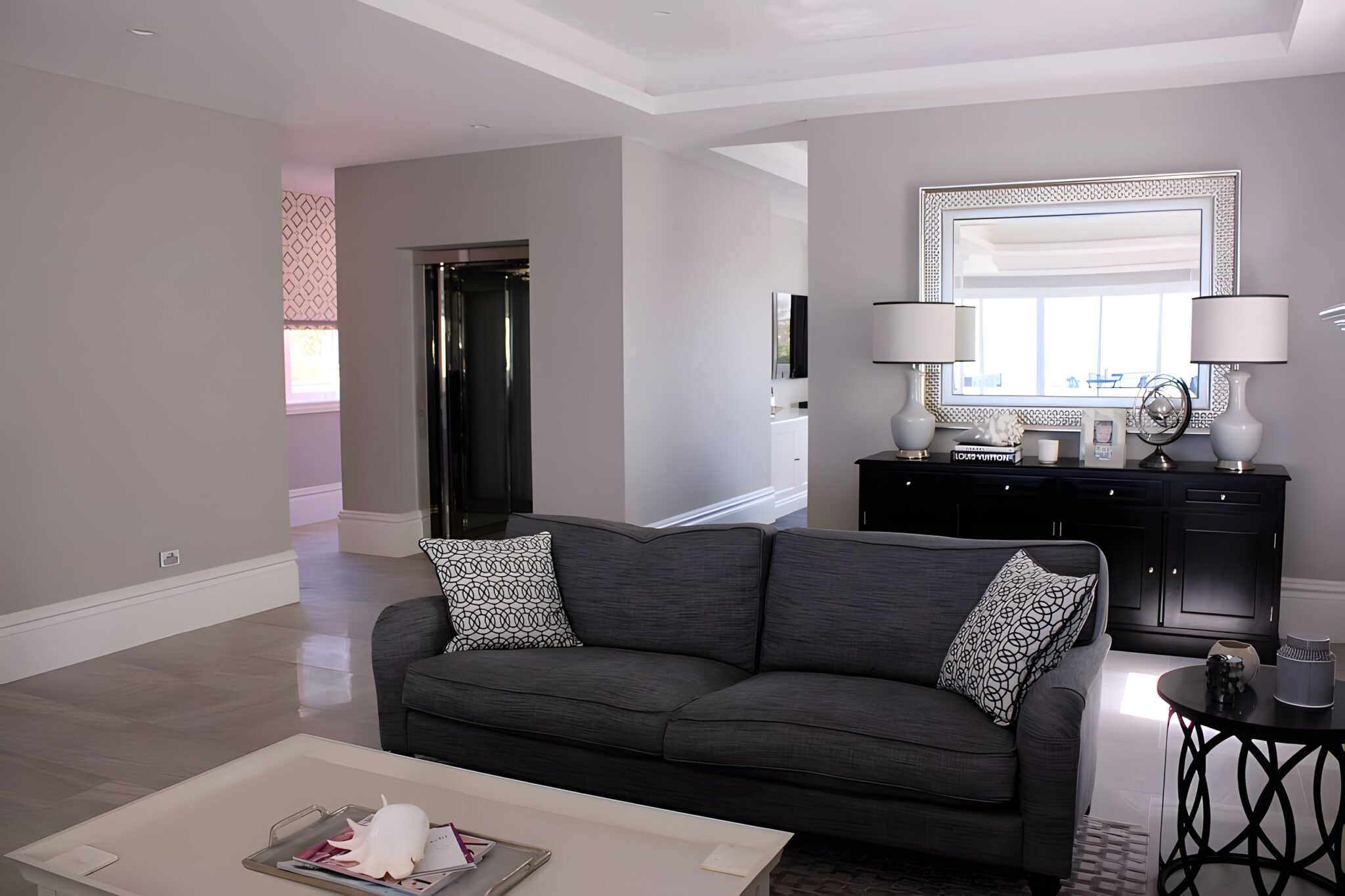 Hamptons-style living room in Main Beach with the glass lift visible in the hallway beyond