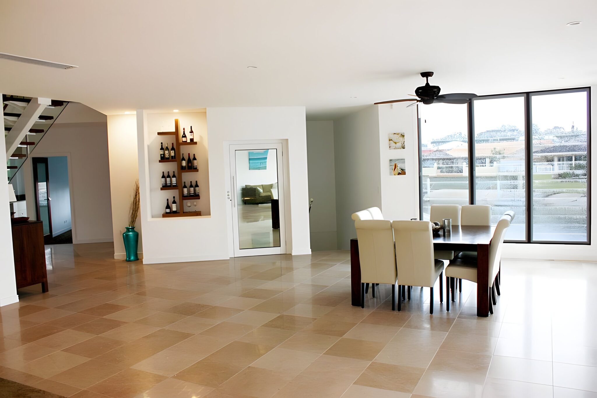 Open-plan dining and living area on the Isle of Capri with the glass lift door beside a wine niche