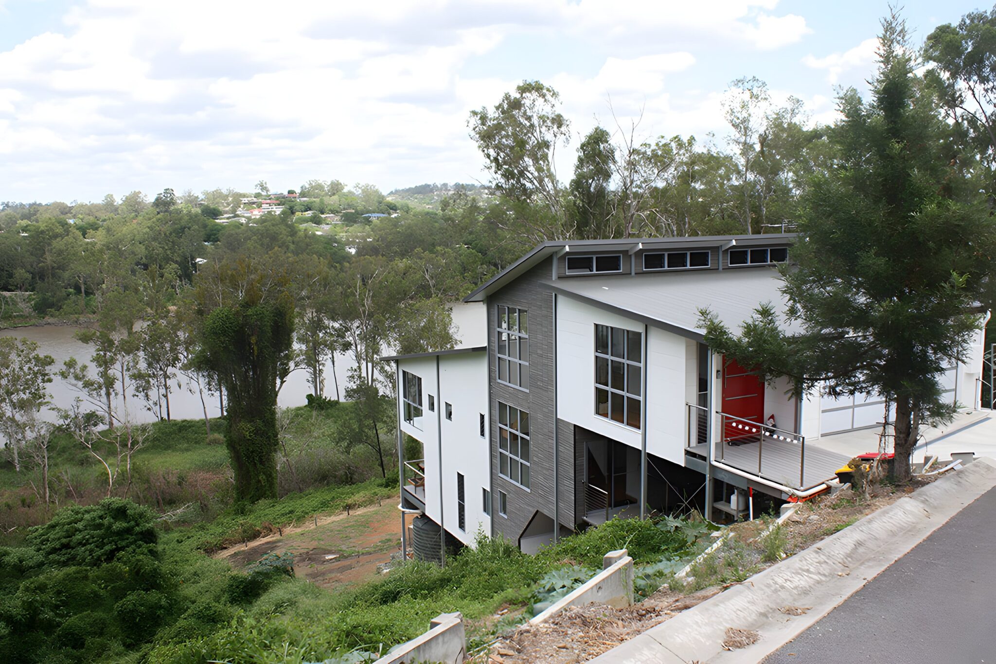 Modern split-level home on a sloping riverside block in Kenmore, Brisbane, with the river and gum trees behind