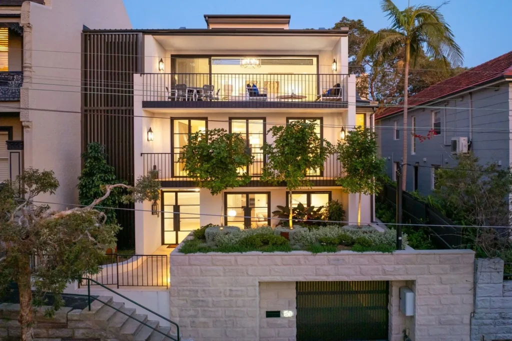 Newly built four-level terrace home lit at dusk in McMahons Point