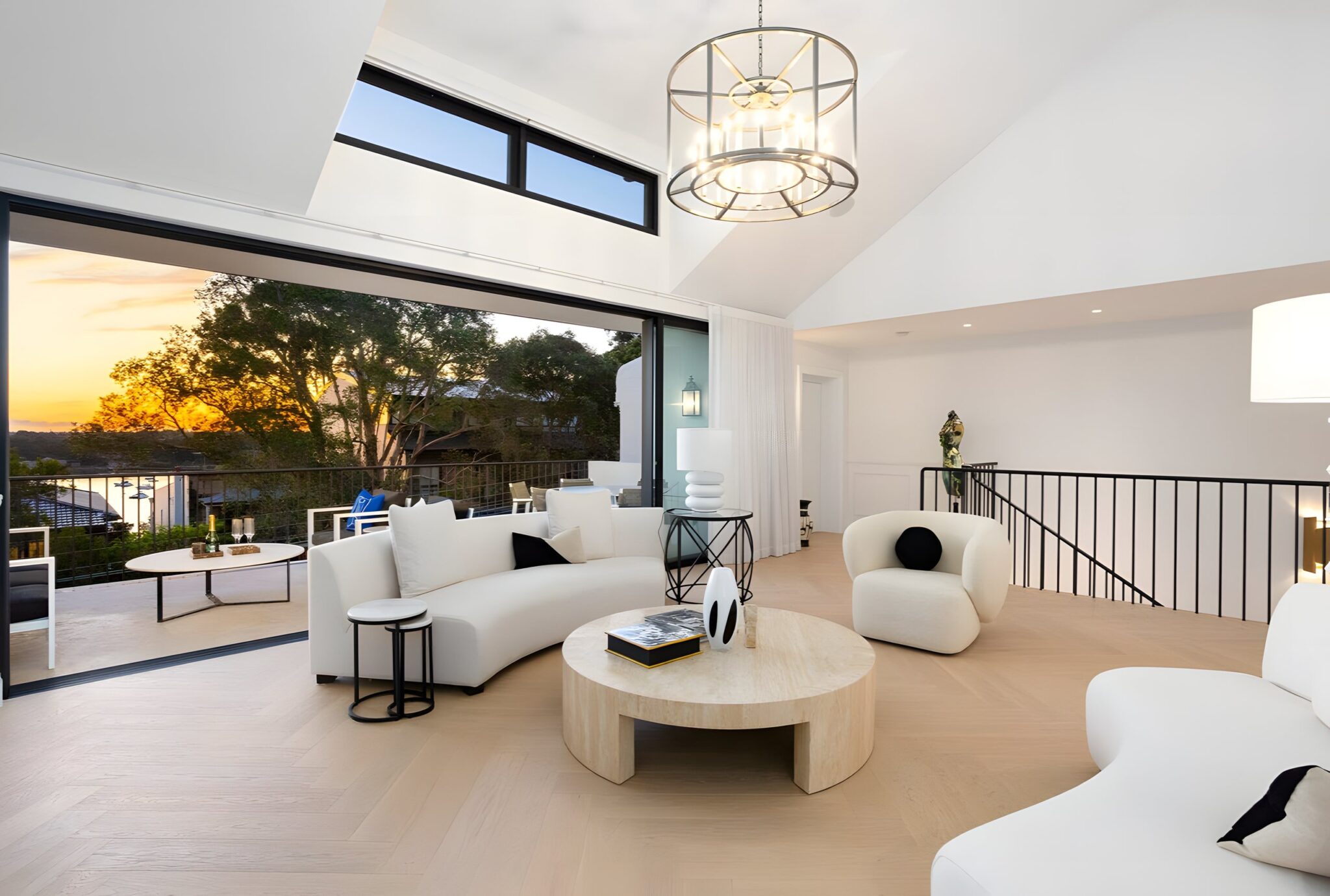 Top-floor living area in a McMahons Point home, with the balcony open to a Sydney sunset