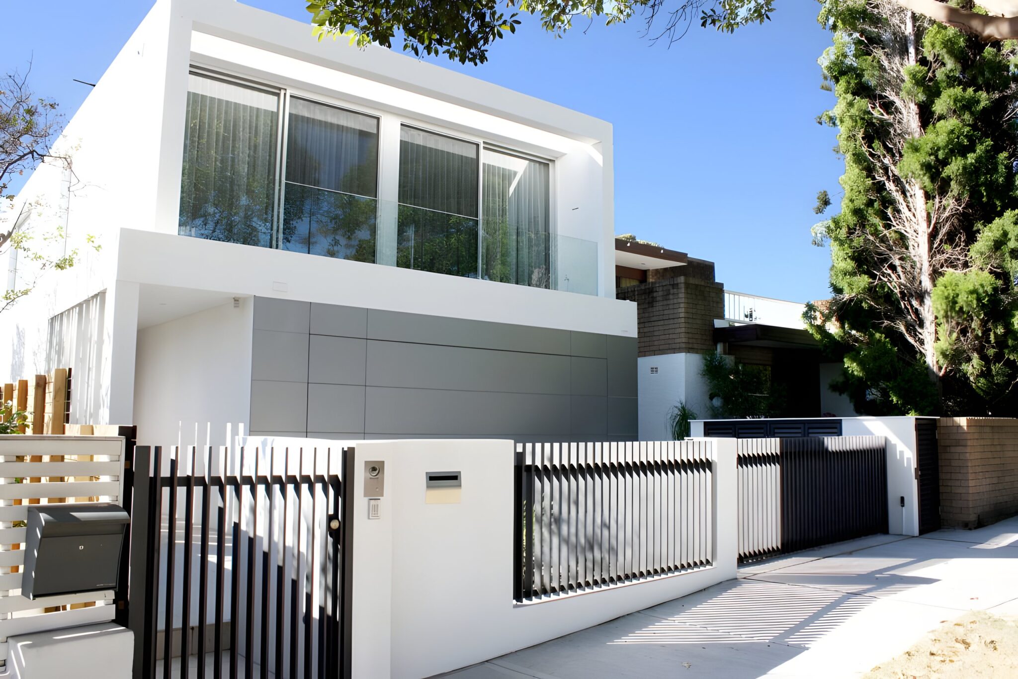 White modern house with a black slatted gate and fence in Bellevue Hill, Sydney