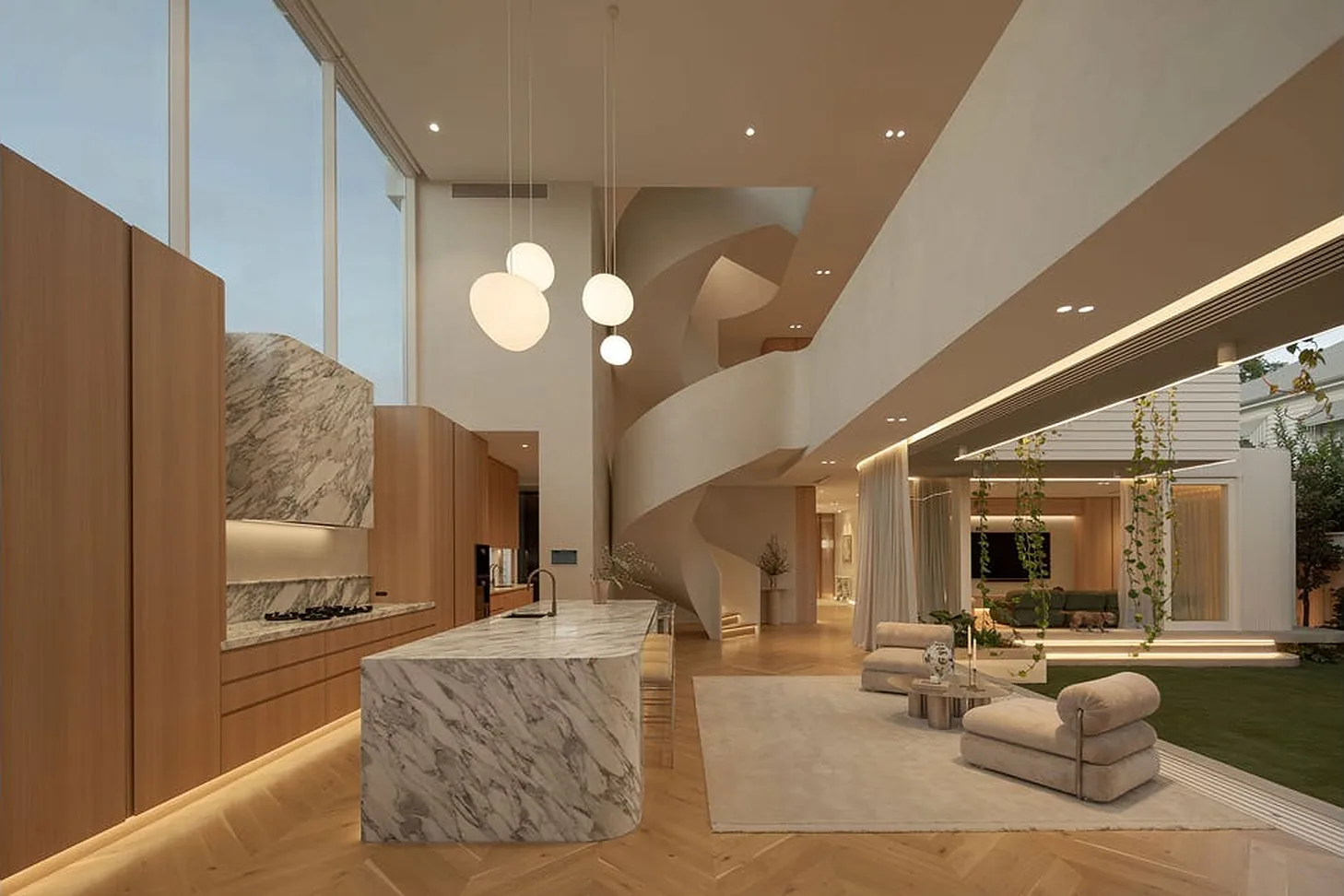 Double-height kitchen with marble island and curved staircase in a New Farm home Double-height kitchen with marble island and curved staircase in a New Farm home