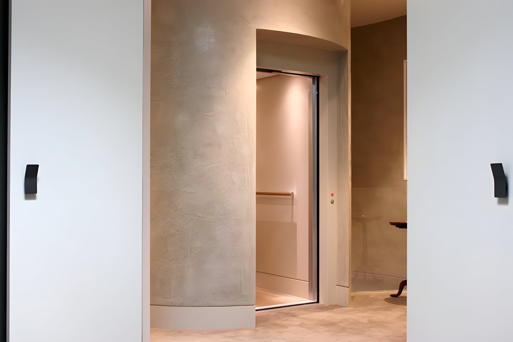 Open lift door set into a round textured grey shaft wall in a new Armadale home