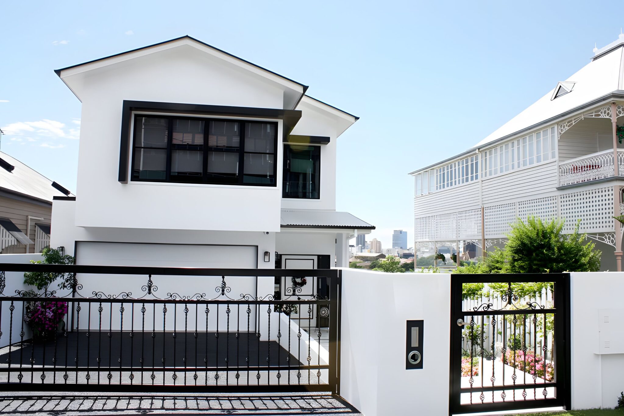 White two-storey new build home with a black steel fence and gate in Red Hill, Brisbane