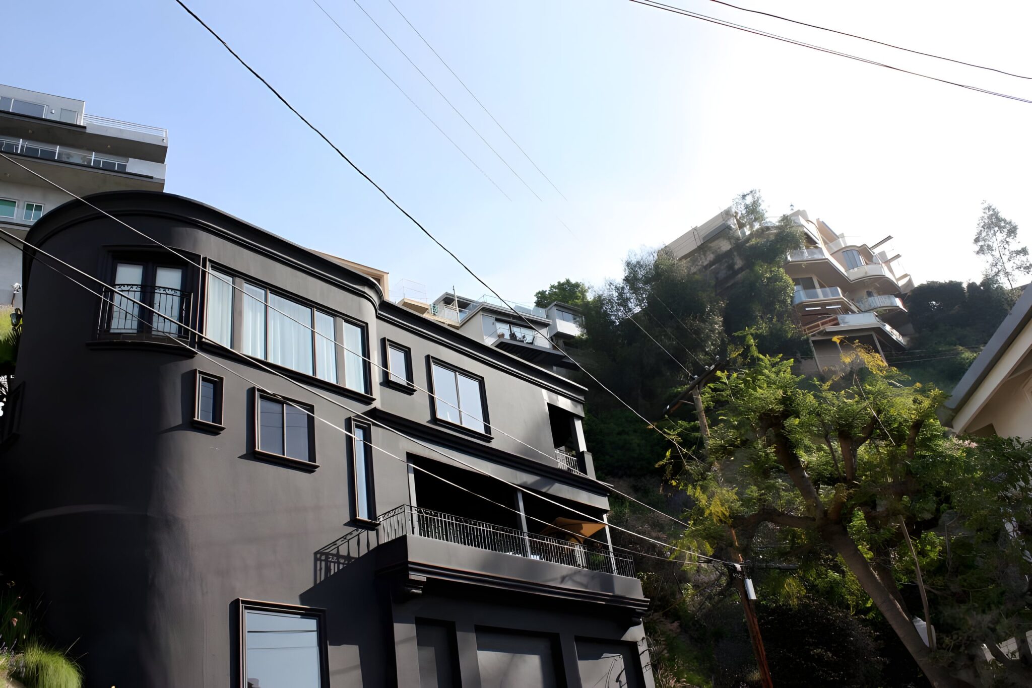 Dark painted mid-century home with balconies on a hillside in the Hollywood Hills