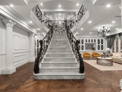 Sweeping marble staircase with ornate wrought-iron balustrades in a French Provincial luxury home